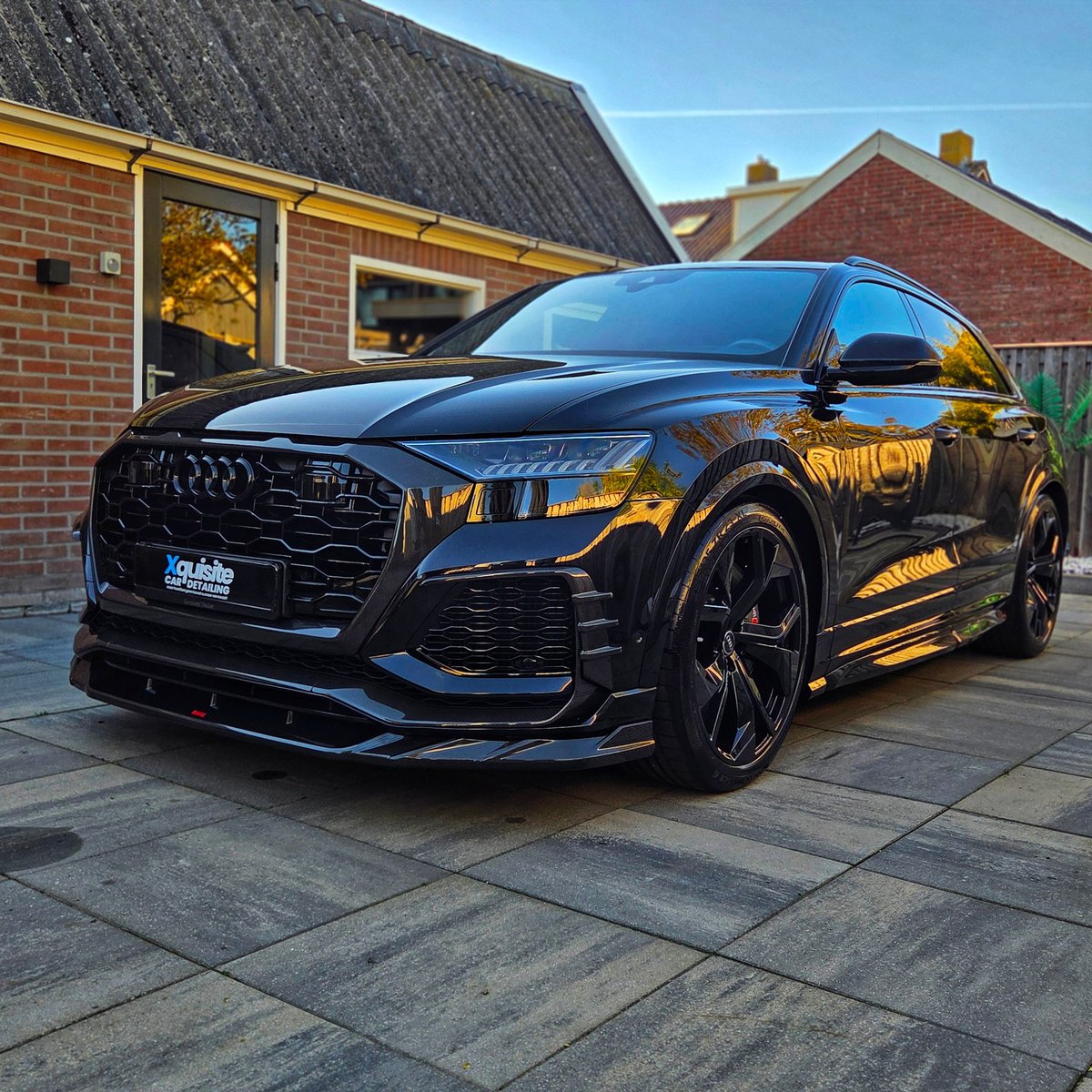 Zwarte luxe SUV geparkeerd op oprit voor woonhuizen
